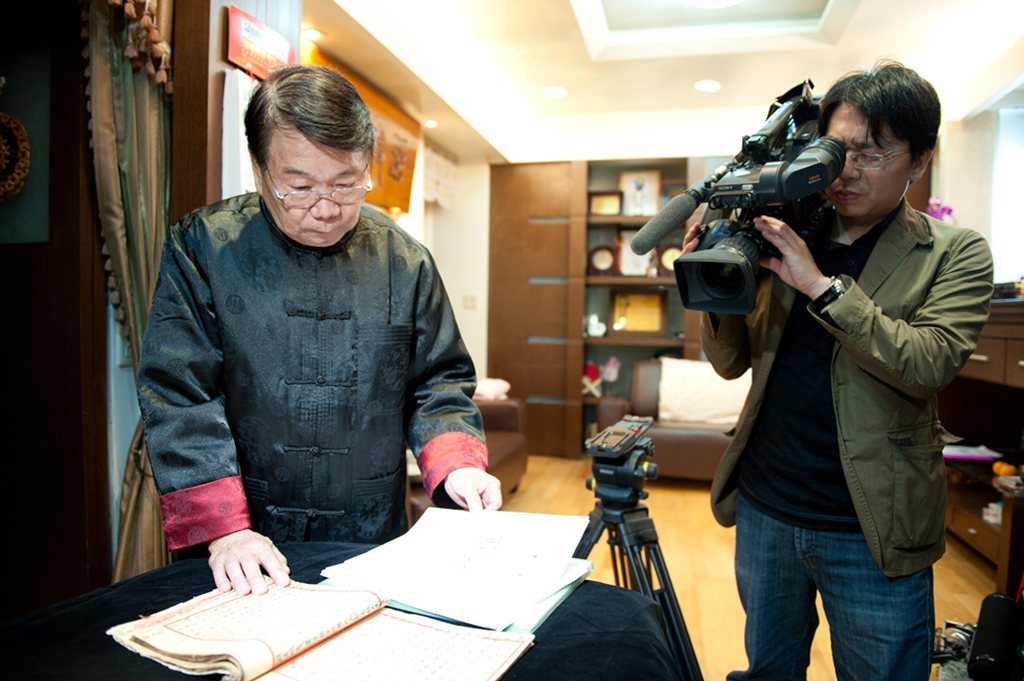 攝影團隊記錄老藝師翻閱手抄曲譜