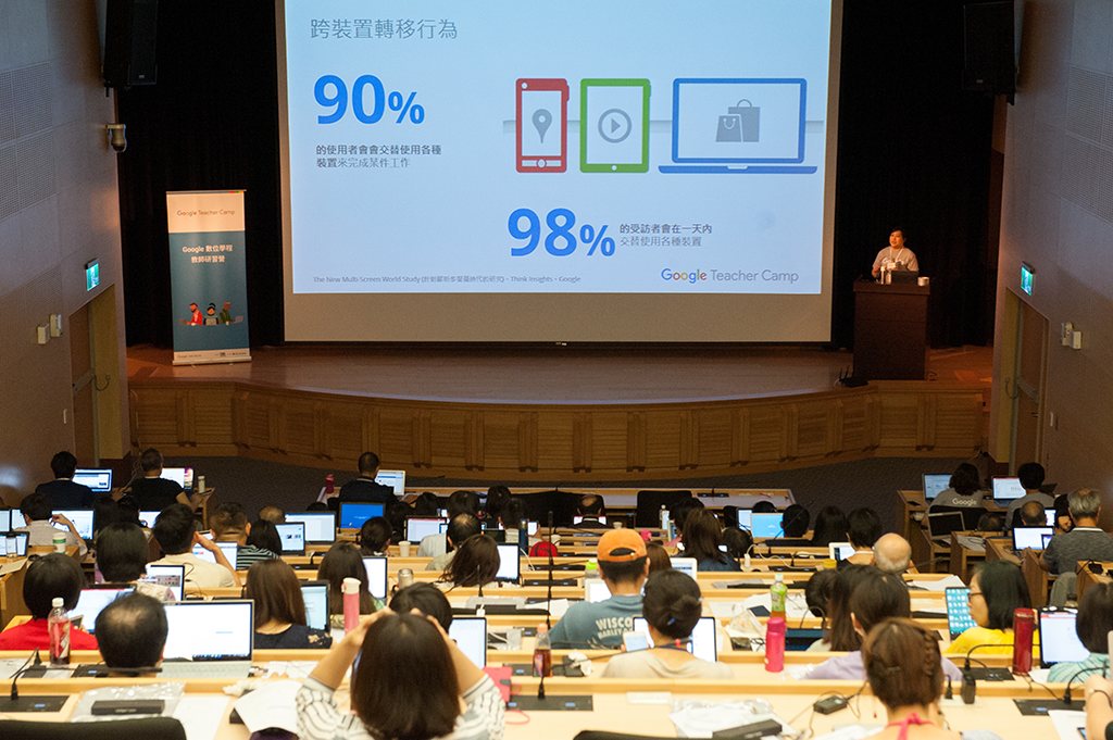A Google Teacher Camp lecture hall, the speaker presenting mobile usage statistics