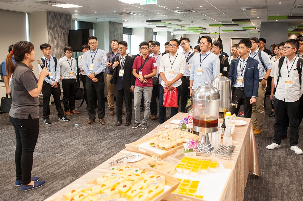Attendees queuing beside the refreshment table at the registration area