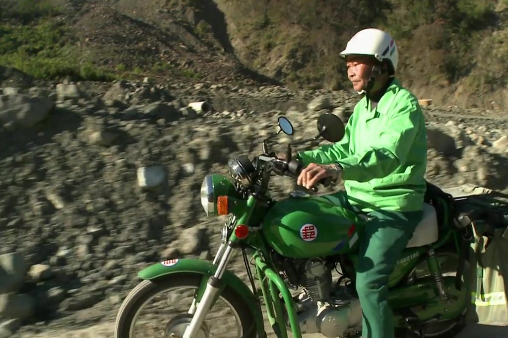 郵務士騎機車行經碎石河床便道
