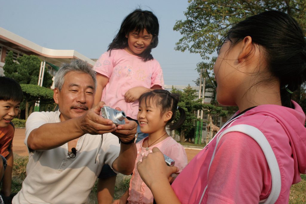 校園戶外，長者與孩童一同玩耍互動